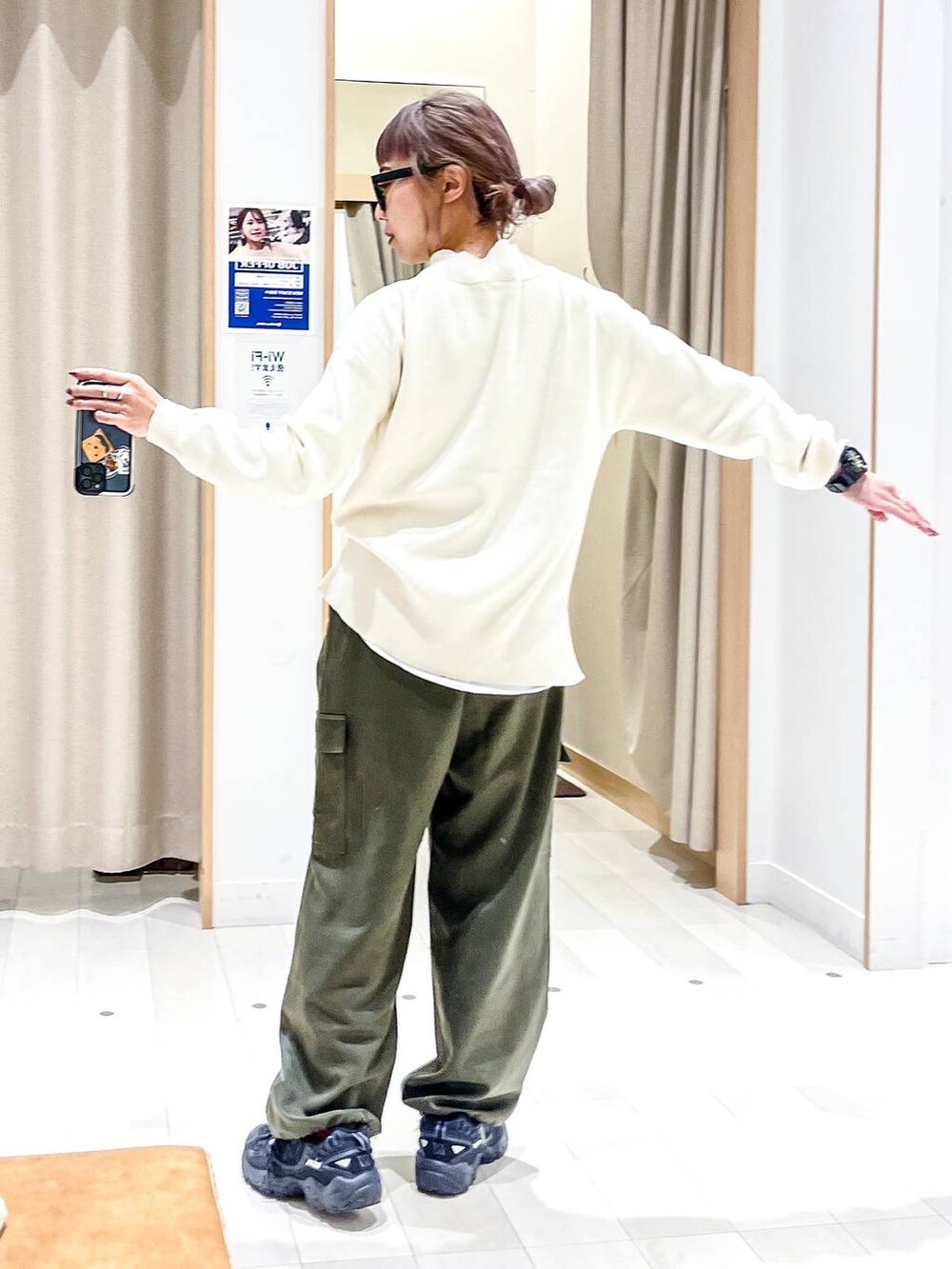 ホワイト系のニット/セーター、ホワイト系のブルゾン、グリーン系のカーゴパンツを着用したレディースの冬コーディネートの8枚目の写真