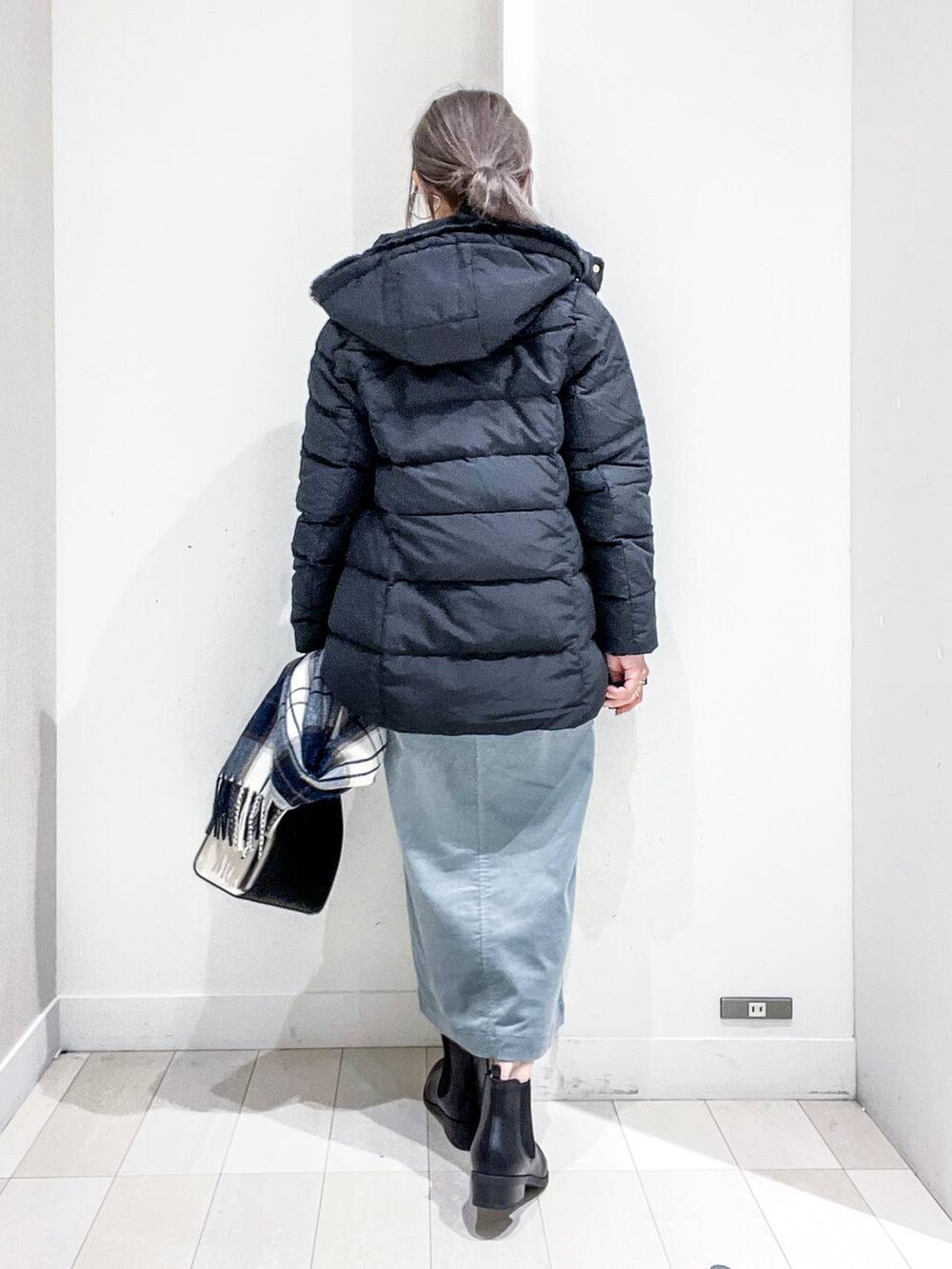 ブラック系のショルダーバッグ、ブラック系のダウンジャケット/コート、グリーン系のスカートを着用したレディースの冬コーディネートの4枚目の写真