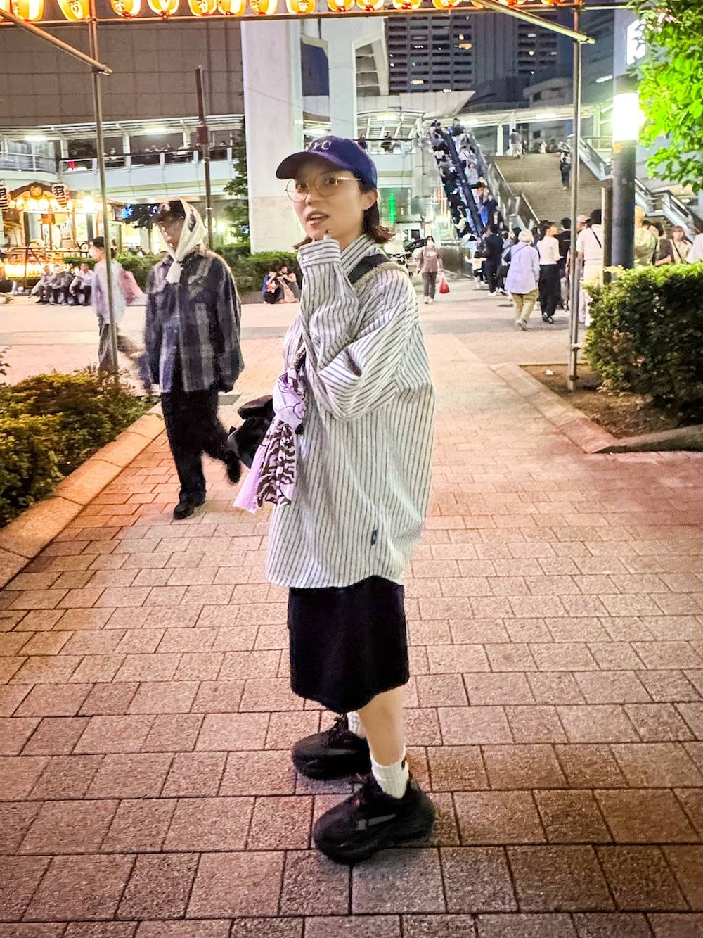 ブラック系のデニムパンツ、ベージュ系のシャツ/ブラウス、ブルー系のキャップを着用したレディースの秋コーディネートの3枚目の写真