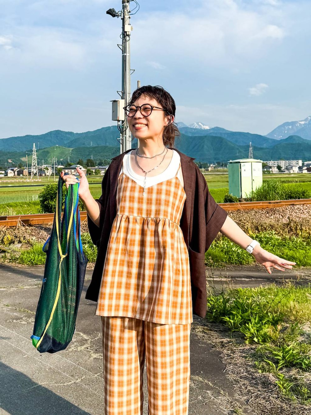 ホワイト系のタンクトップ、ブラック系のサンダル、ブラウン系のテーラードジャケットを着用したレディースの夏コーディネートの8枚目の写真