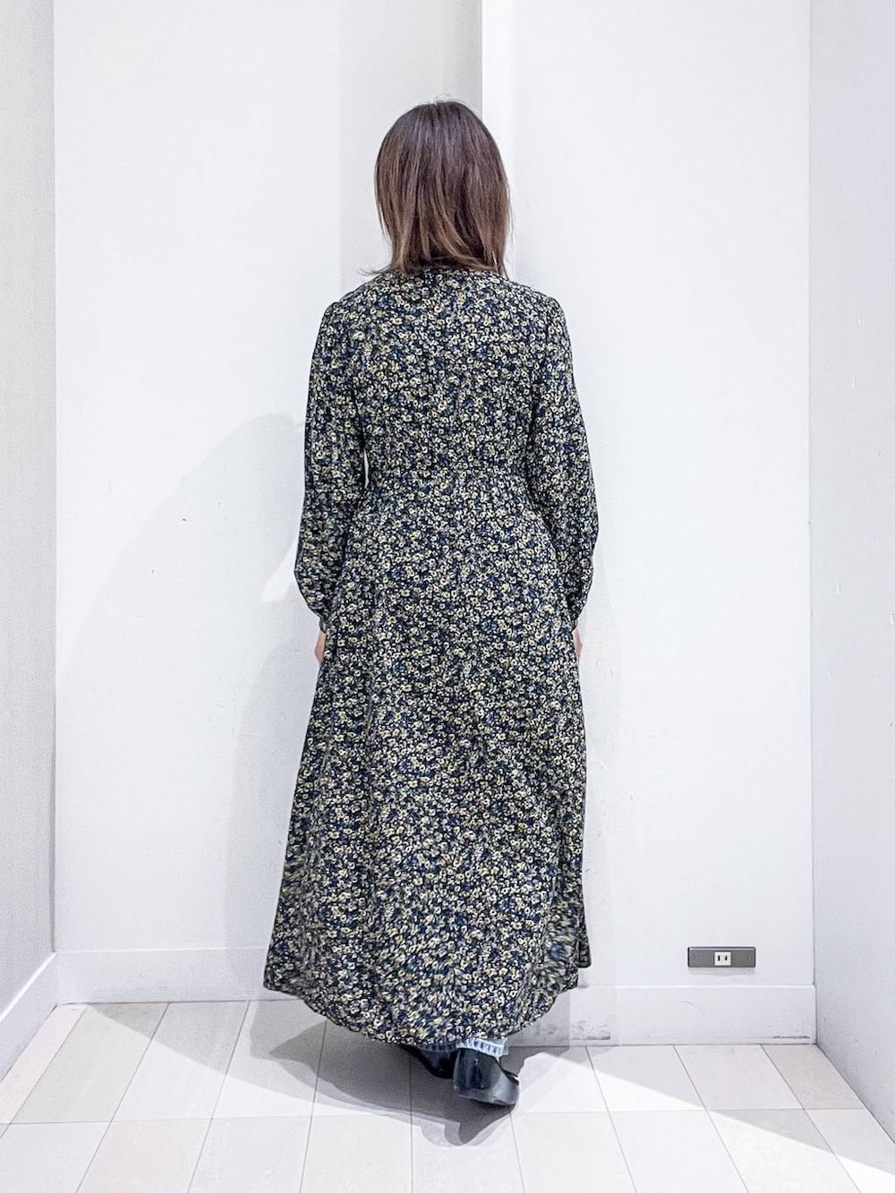 ブルー系のデニムパンツ、ブラック系のワンピース、ブラック系のバレエシューズを着用したレディースの秋コーディネートの8枚目の写真