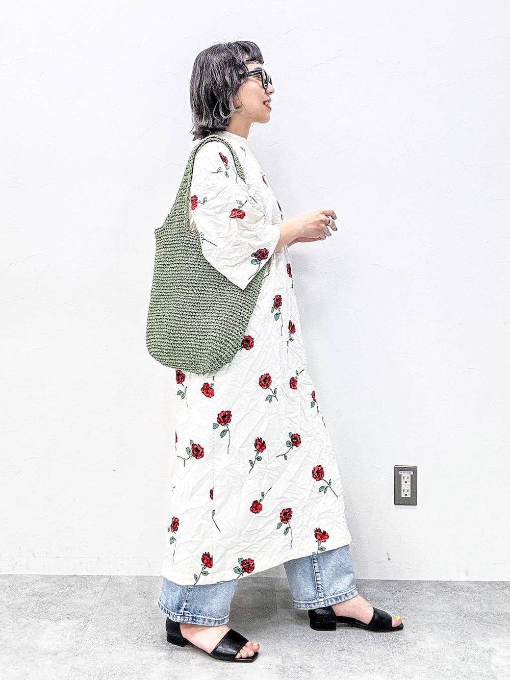 グリーン系のショルダーバッグ、ブラック系のサンダル、ブルー系のデニムパンツを着用したレディースの春コーディネートの6枚目の写真