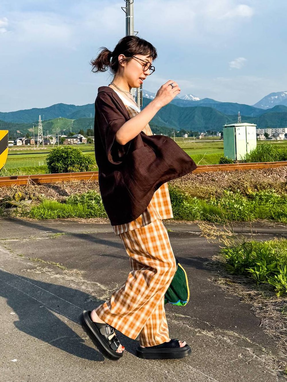 ホワイト系のタンクトップ、ブラック系のサンダル、ブラウン系のテーラードジャケットを着用したレディースの夏コーディネートの6枚目の写真