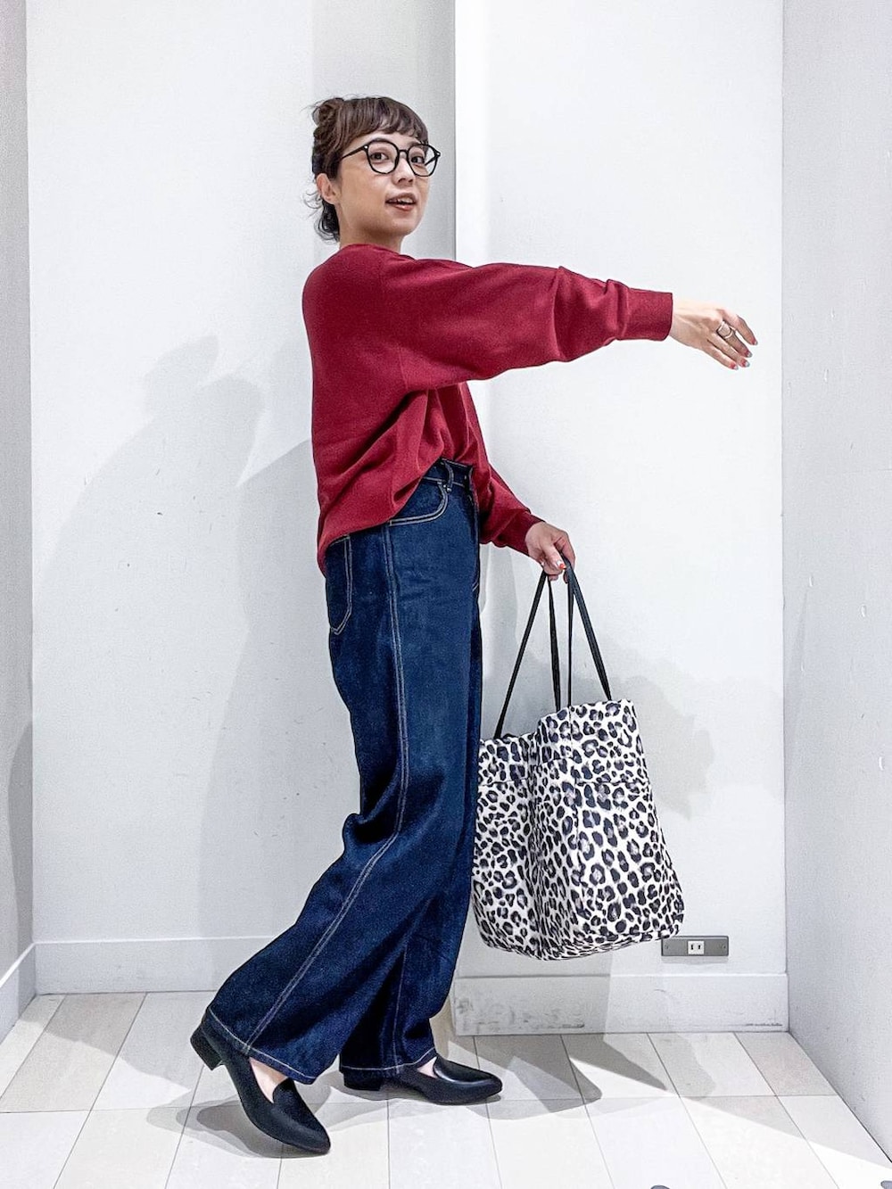 ブラック系のパンプス、レッド系のニット/セーター、ブルー系のデニムパンツを着用したレディースの秋コーディネートの5枚目の写真