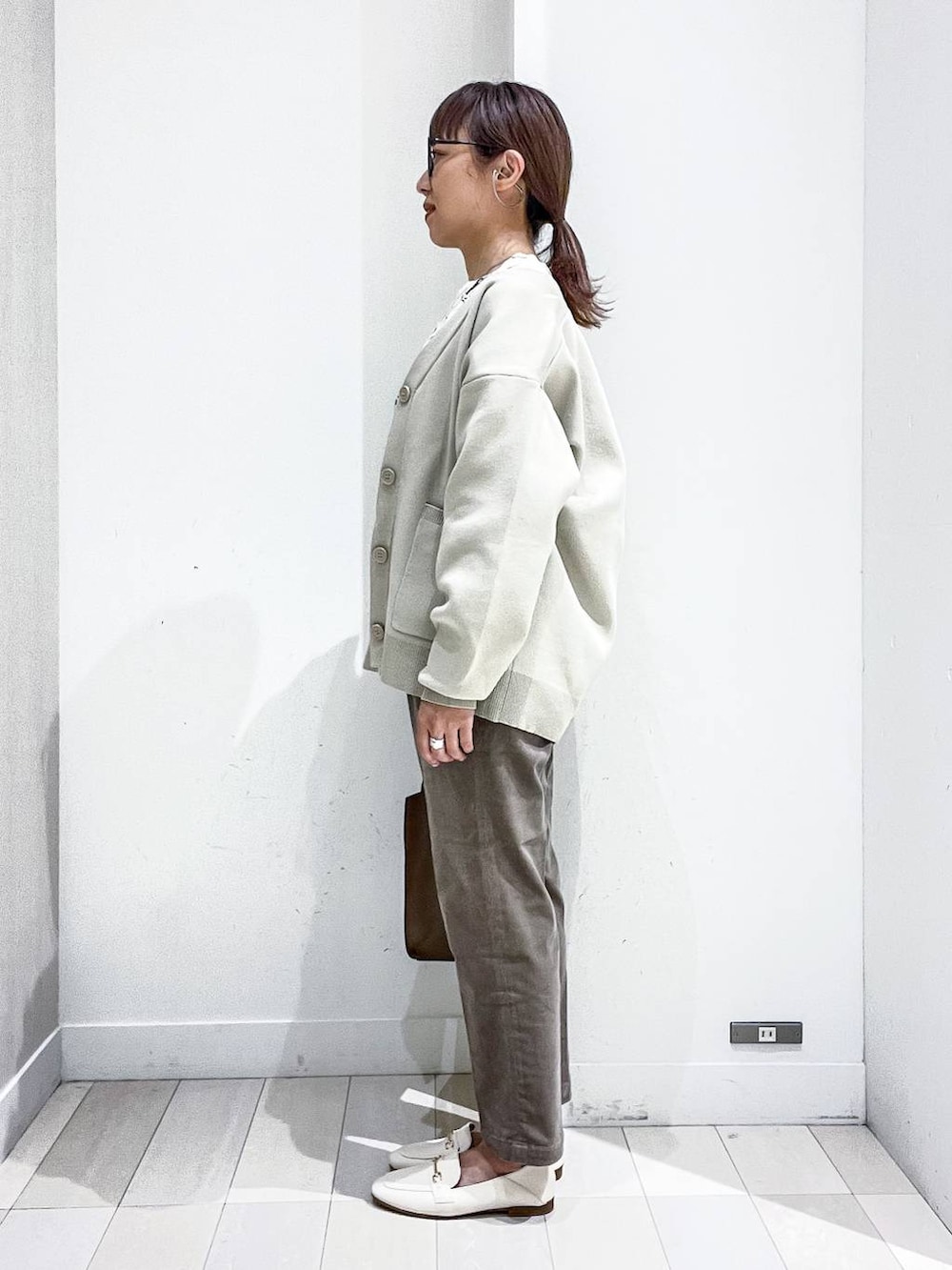 ホワイト系のローファー、ベージュ系のカーディガン/ボレロ、ホワイト系のシャツ/ブラウスを着用したレディースの秋コーディネートの3枚目の写真