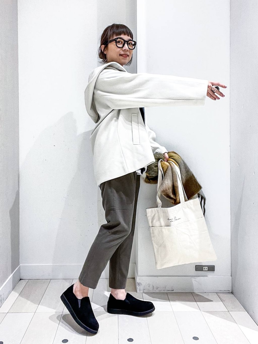 ホワイト系のトートバッグ、ホワイト系のその他アウター、その他のTシャツ/カットソーを着用したレディースの秋コーディネートの5枚目の写真
