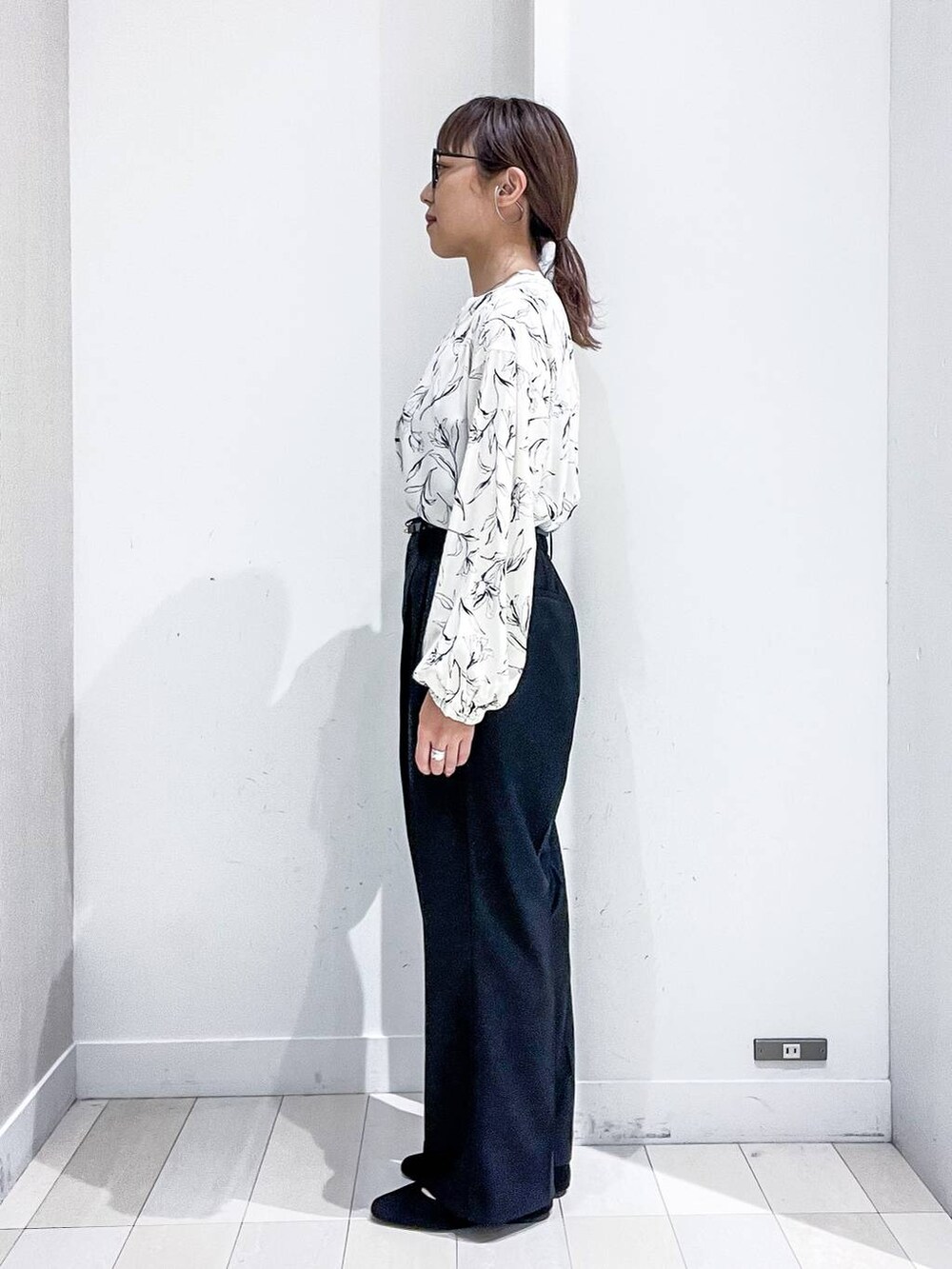 ブラック系のその他パンツ、ホワイト系のシャツ/ブラウス、グレー系のカーディガン/ボレロを着用したレディースの秋コーディネートの7枚目の写真