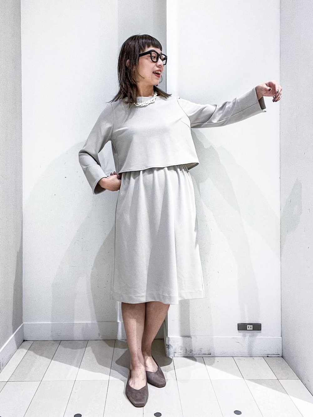 ベージュ系のパンプス、ホワイト系のノーカラージャケット、ベージュ系のワンピースを着用したレディースの冬コーディネートの6枚目の写真