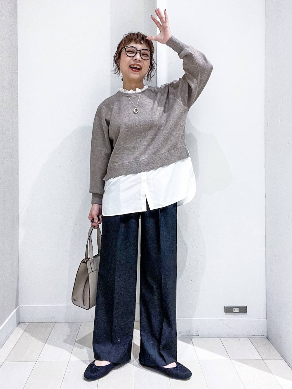 ベージュ系のショルダーバッグ、グレー系のノーカラーコート、ブラック系のその他パンツを着用したレディースの秋コーディネートの6枚目の写真