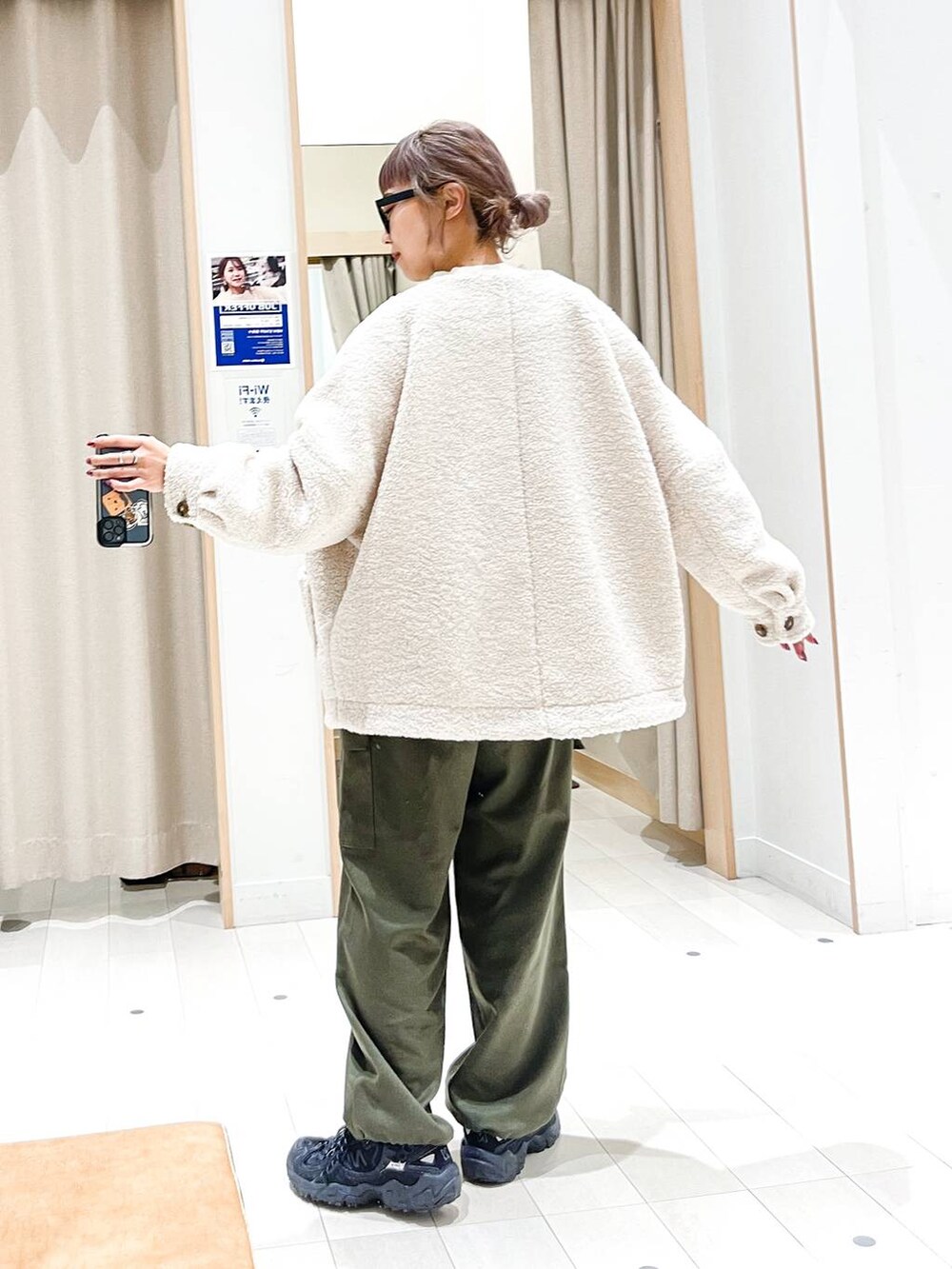 ホワイト系のニット/セーター、ホワイト系のブルゾン、グリーン系のカーゴパンツを着用したレディースの冬コーディネートの4枚目の写真
