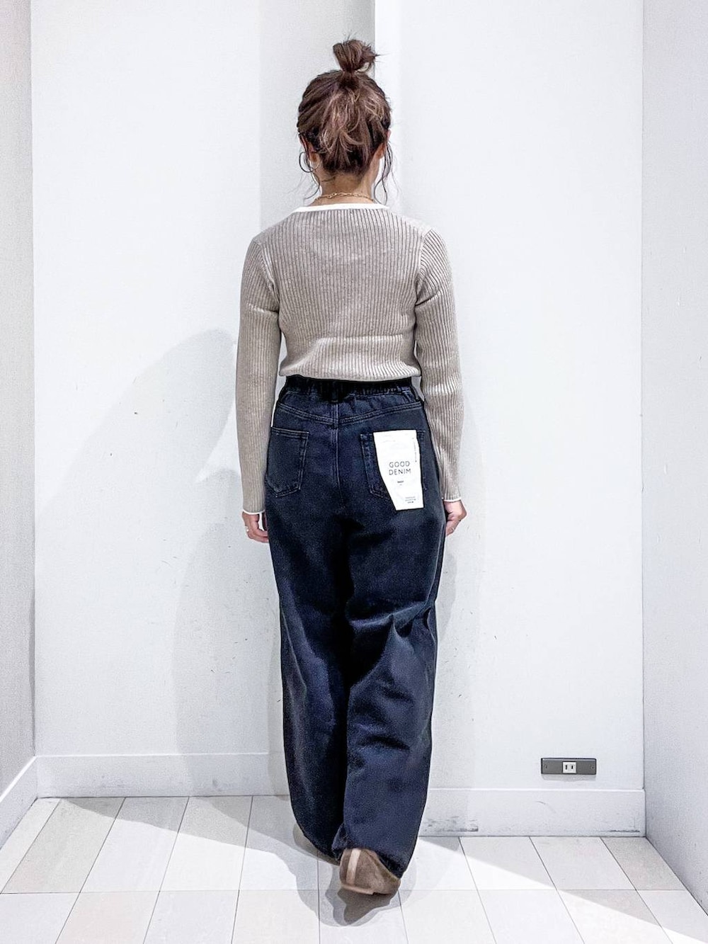 ベージュ系のニット/セーター、ブラック系のデニムパンツ、ベージュ系のトートバッグを着用したレディースの秋コーディネートの8枚目の写真