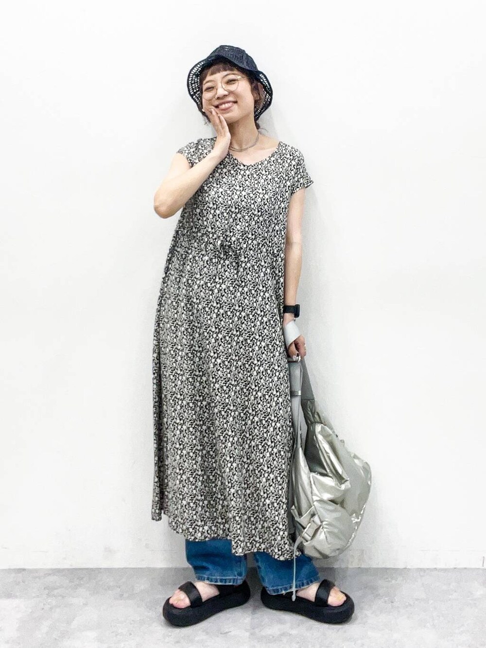 シルバー系のショルダーバッグ、ブルー系のデニムパンツ、ブラック系のサンダルを着用したレディースの夏コーディネートの7枚目の写真