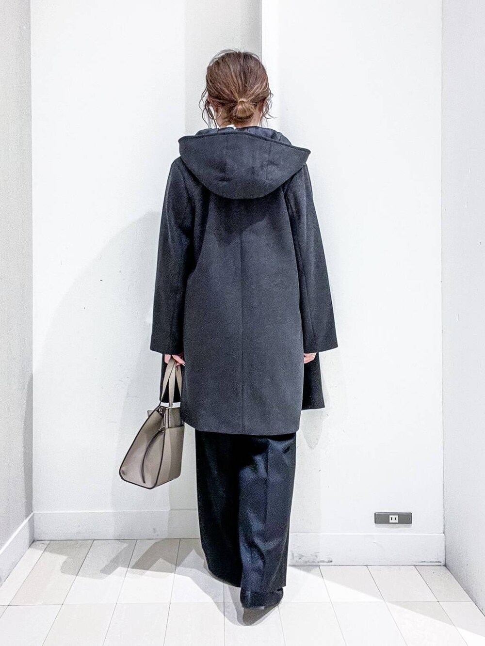 ベージュ系のショルダーバッグ、グレー系のノーカラーコート、ブラック系のその他パンツを着用したレディースの秋コーディネートの4枚目の写真