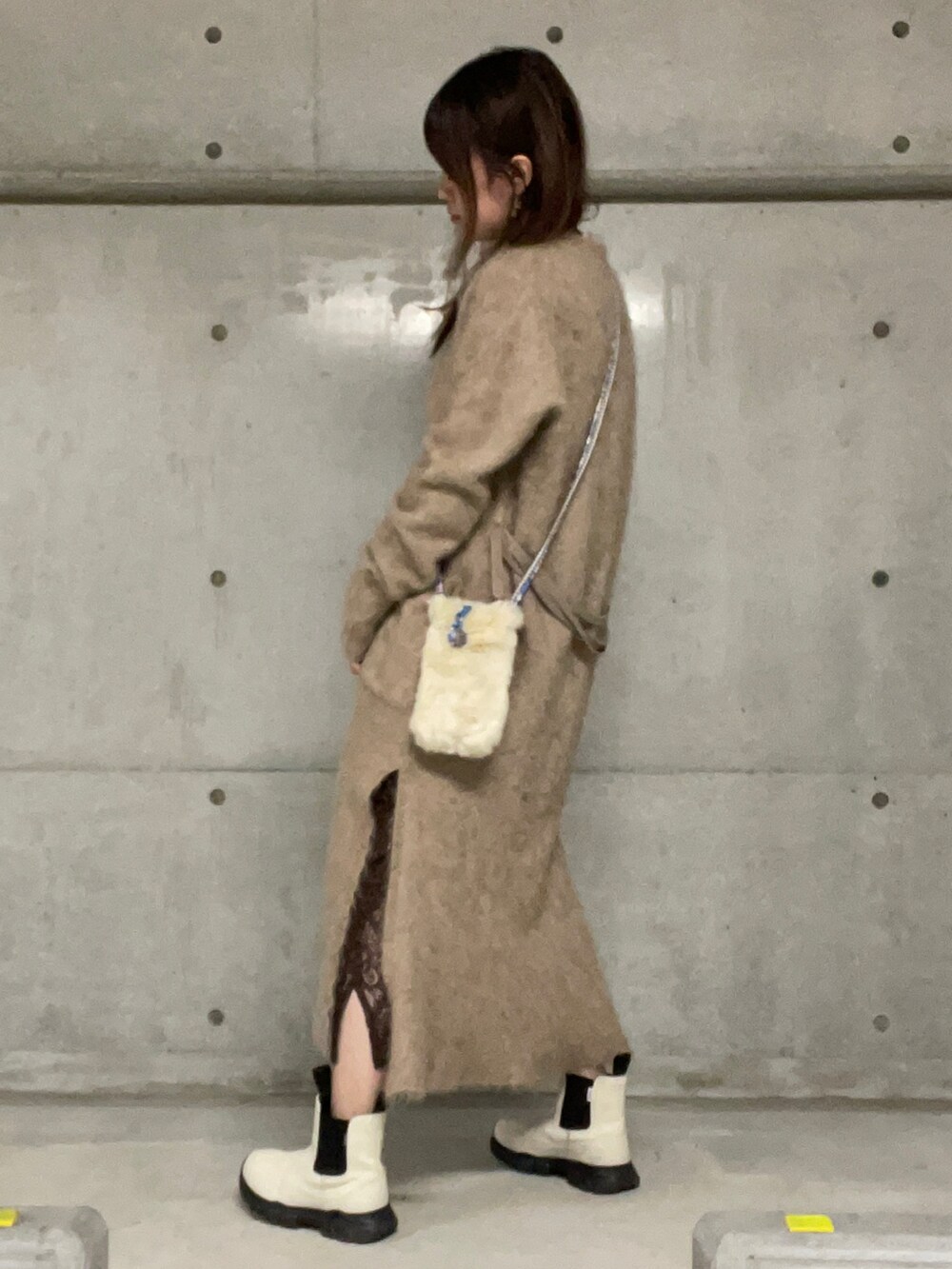 ブラウン系のスカート、グレー系のトップス、ホワイト系のブーツを着用したレディースの秋コーディネートの2枚目の写真