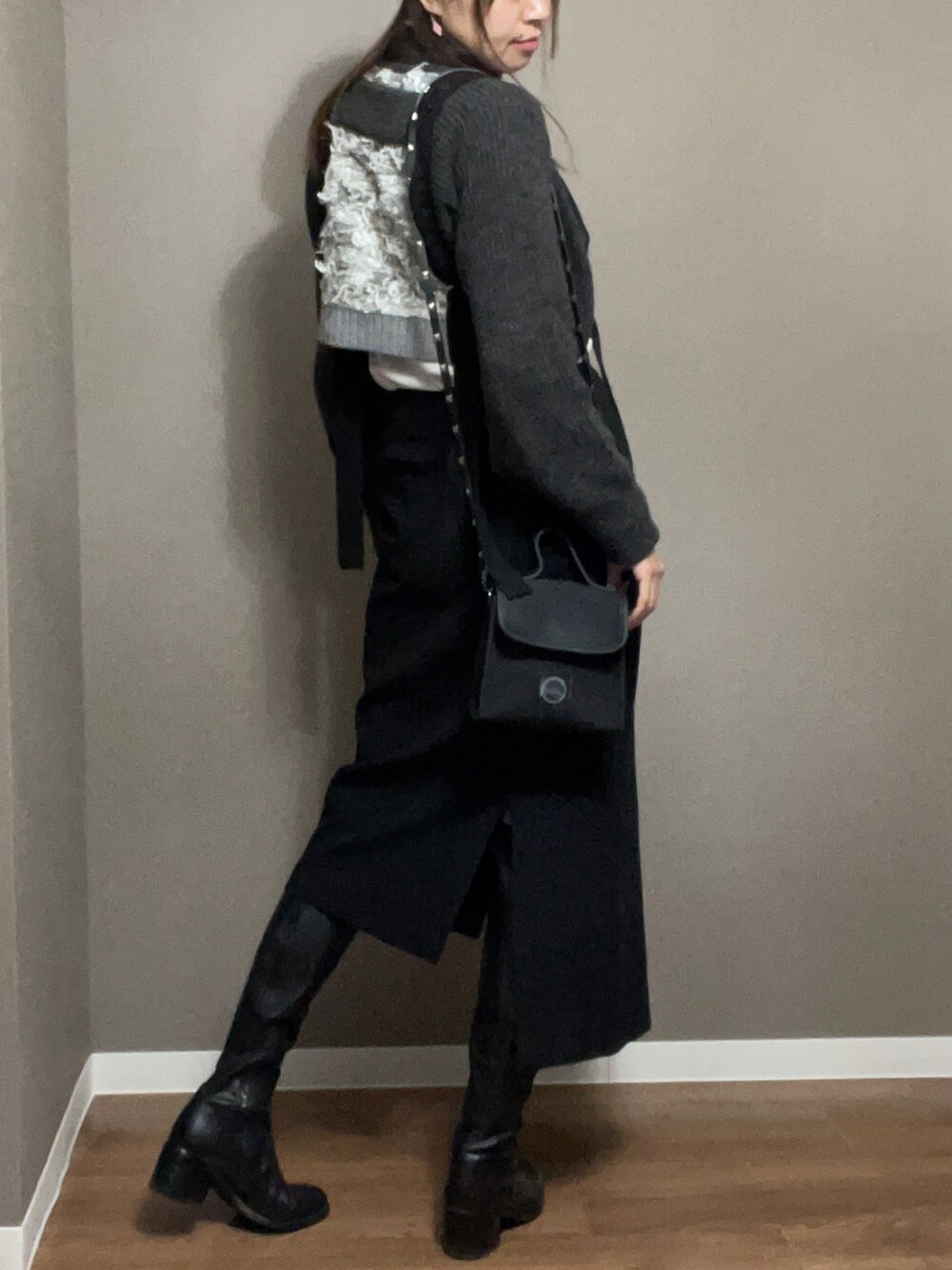 ブラック系のショルダーバッグ、ブラック系のスカート、グレー系のニット/セーターを着用したレディースの冬コーディネートの3枚目の写真