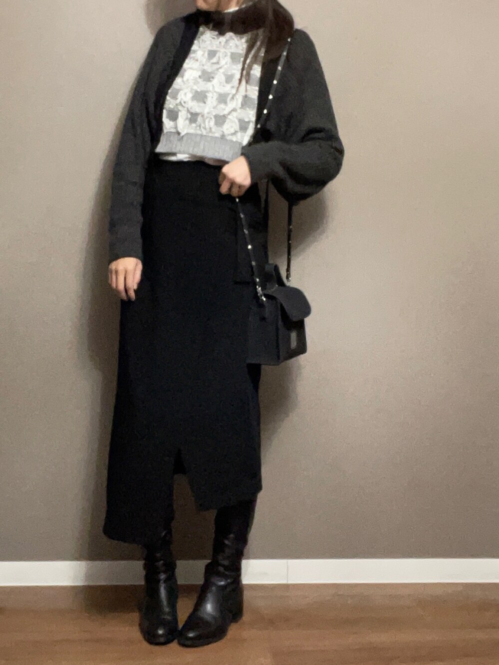 ブラック系のショルダーバッグ、ブラック系のスカート、グレー系のニット/セーターを着用したレディースの冬コーディネートの4枚目の写真