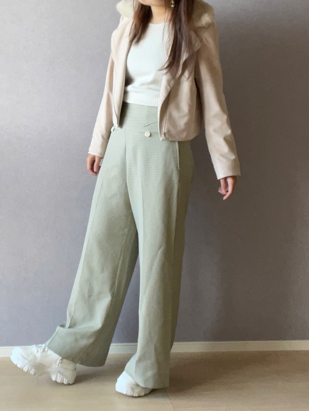 ベージュ系のライダースジャケット、ホワイト系のニット/セーター、グリーン系のその他パンツを着用したレディースの秋コーディネートの2枚目の写真