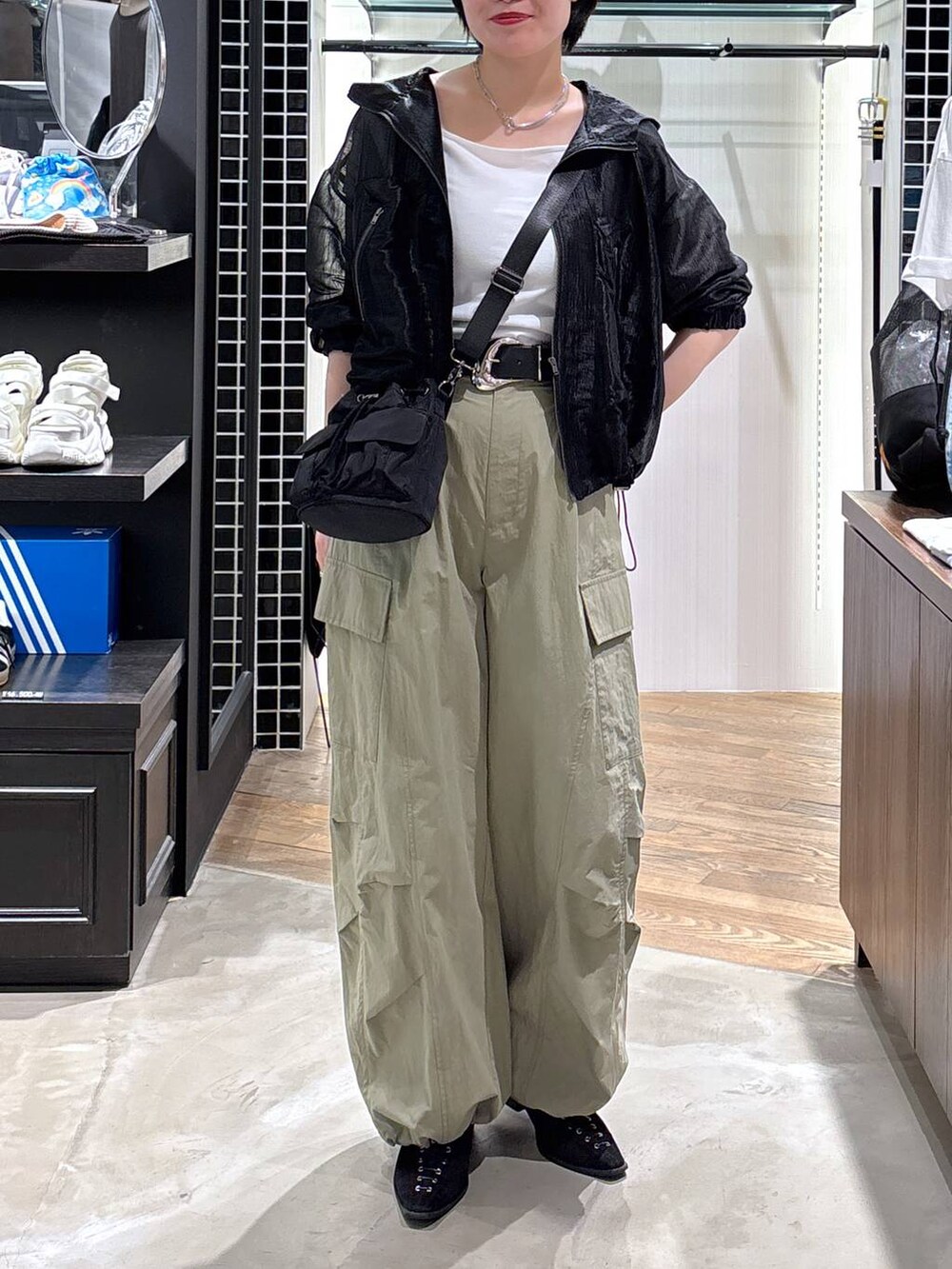 ブラック系のパンプス、グリーン系のカーゴパンツ、ブラック系のブルゾンを着用したレディースの春コーディネートの5枚目の写真