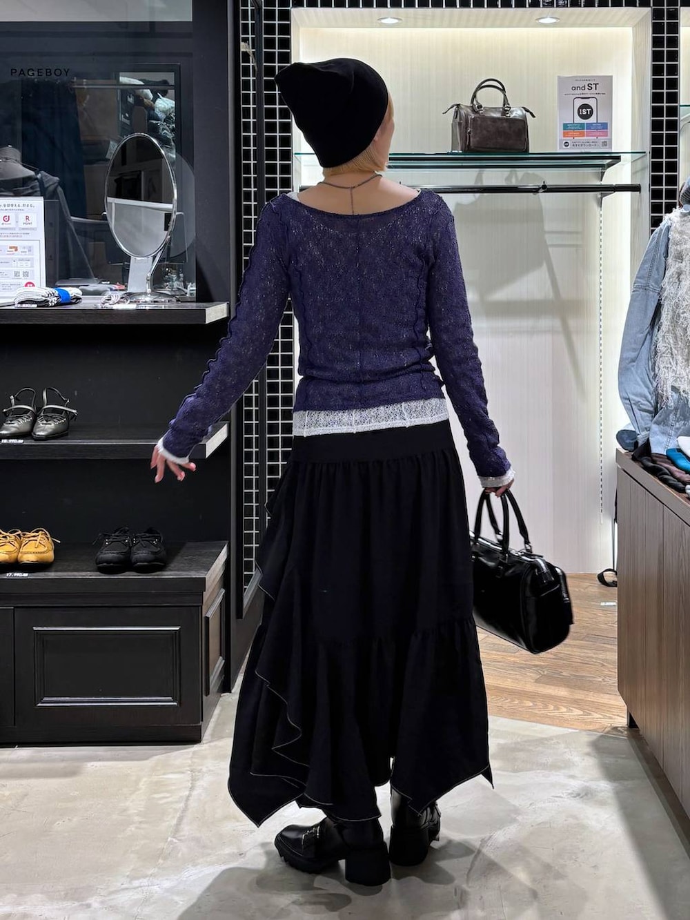 ブラック系のブーツ、ブラック系のスカート、ブラック系のショルダーバッグを着用したレディースの春コーディネートの8枚目の写真