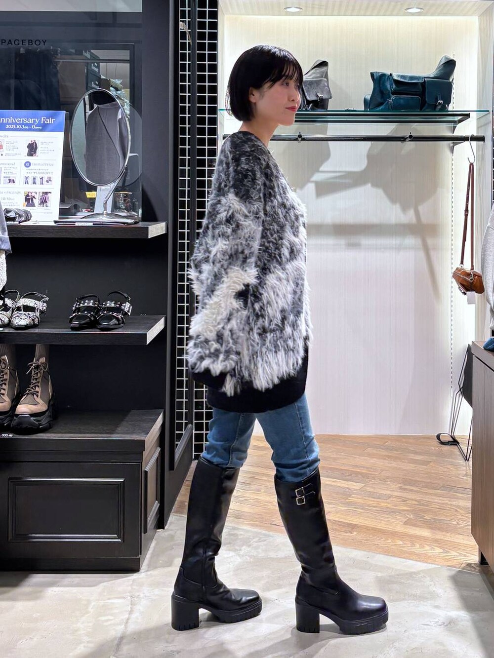 ホワイト系のタンクトップ、ブラック系のカーディガン/ボレロ、ブラック系のブーツを着用したレディースの秋コーディネートの5枚目の写真