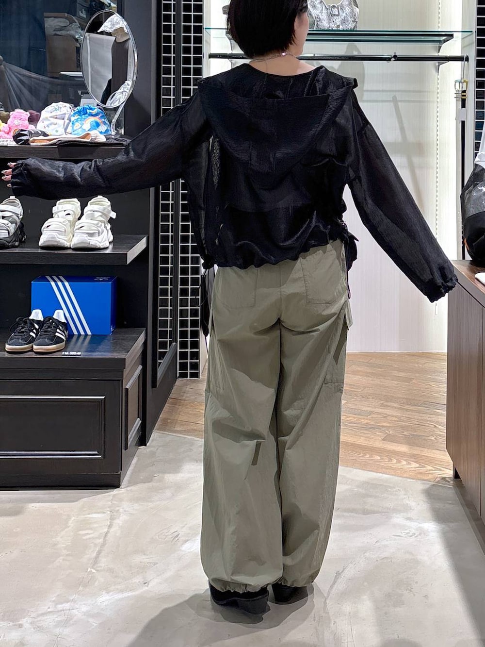 ブラック系のパンプス、グリーン系のカーゴパンツ、ブラック系のブルゾンを着用したレディースの春コーディネートの2枚目の写真