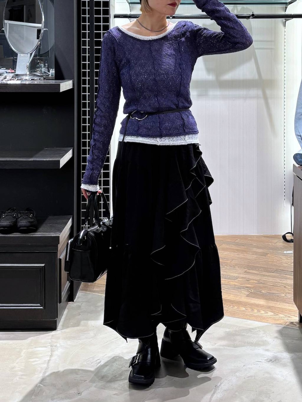 ブラック系のブーツ、ブラック系のスカート、ブラック系のショルダーバッグを着用したレディースの春コーディネートの7枚目の写真