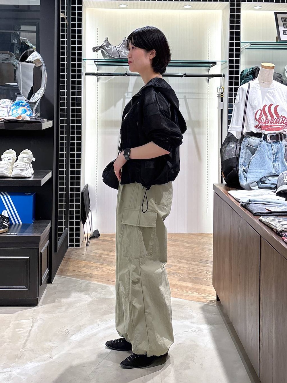ブラック系のパンプス、グリーン系のカーゴパンツ、ブラック系のブルゾンを着用したレディースの春コーディネートの4枚目の写真