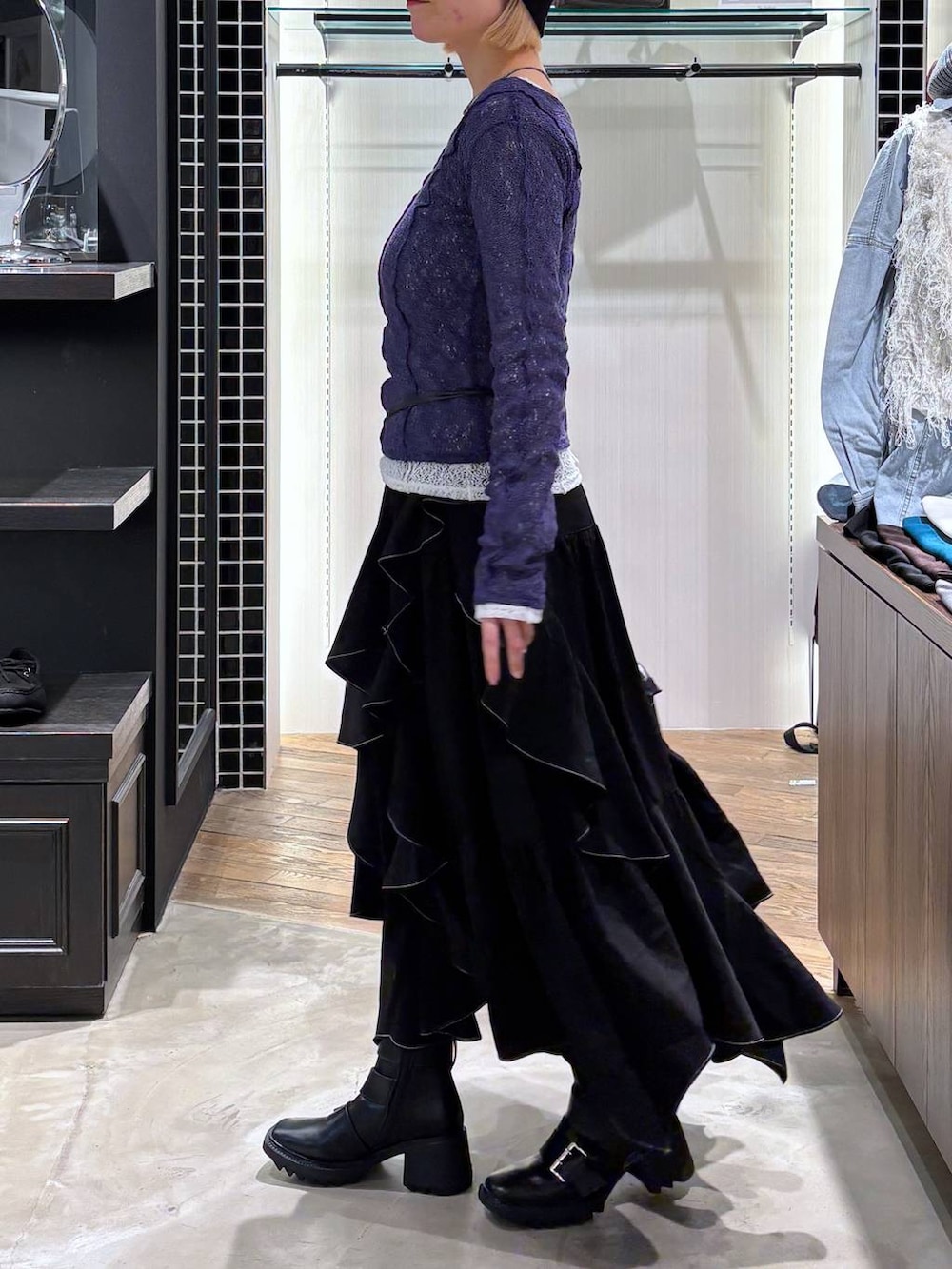 ブラック系のブーツ、ブラック系のスカート、ブラック系のショルダーバッグを着用したレディースの春コーディネートの4枚目の写真