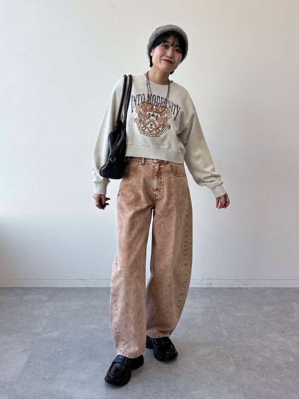 ブラック系のボストンバッグ、ブラック系のローファー、ブラウン系のデニムパンツを着用したレディースの冬コーディネートの8枚目の写真