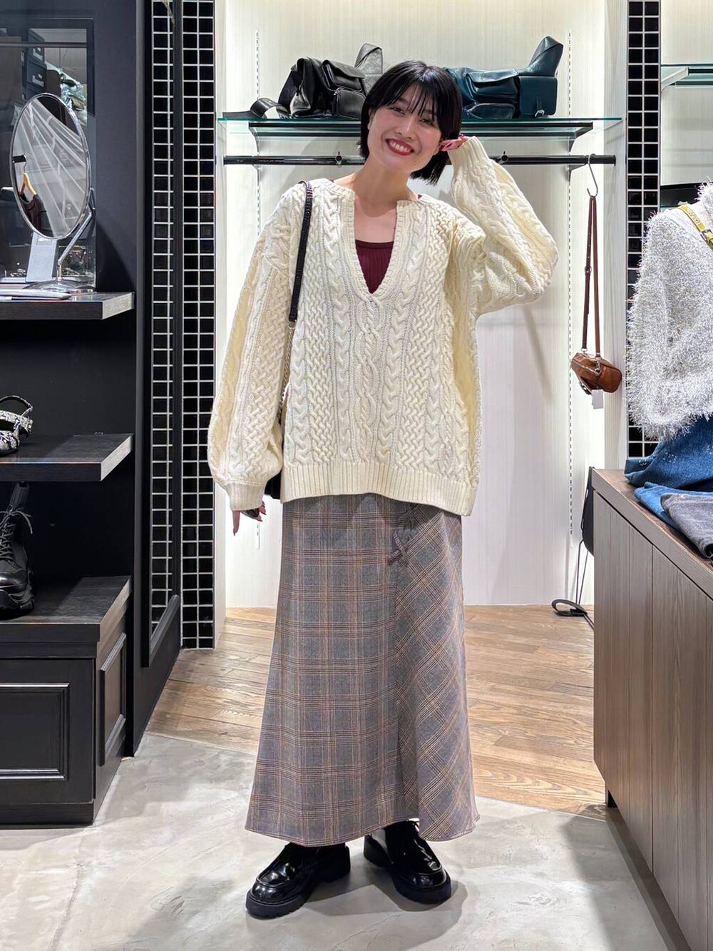 レッド系のタンクトップ、ブラック系のハンドバッグ、ホワイト系のニット/セーターを着用したレディースの秋コーディネートの9枚目の写真