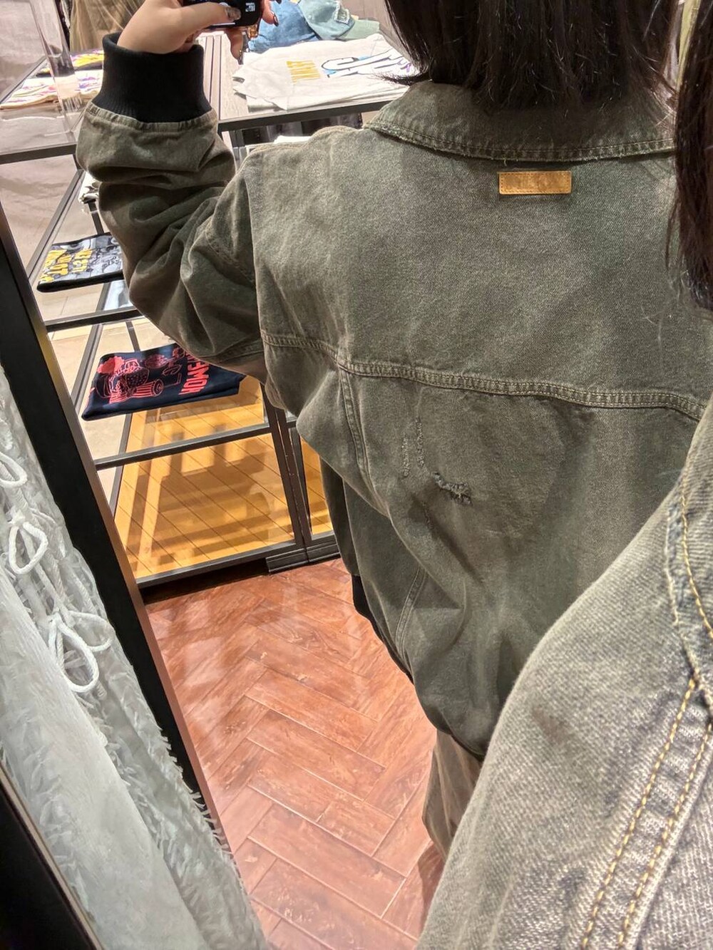 ブラック系のブルゾン、ブラック系のデニムパンツを着用したレディースの冬コーディネートの3枚目の写真