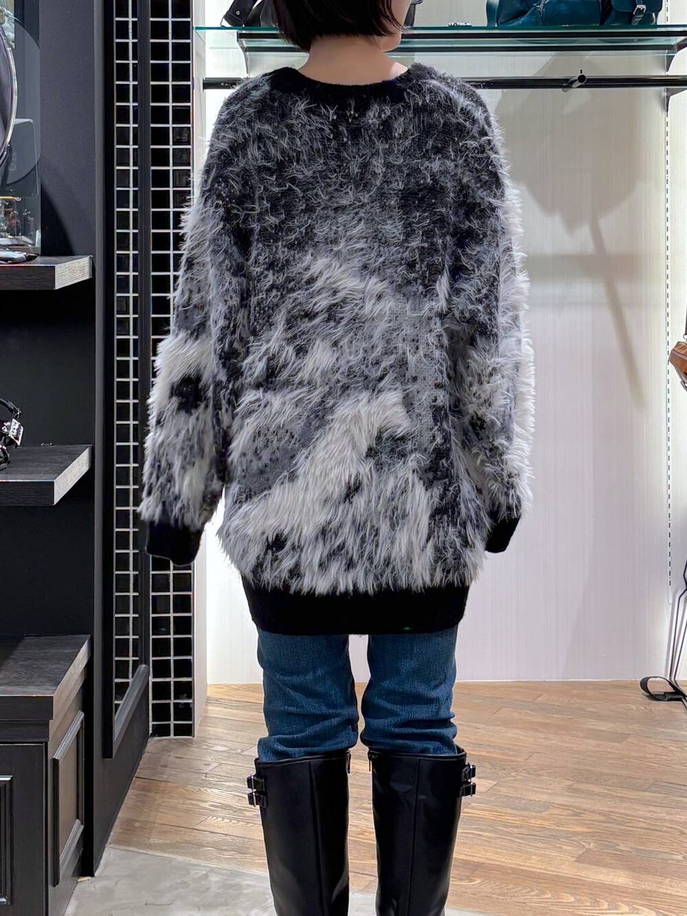 ホワイト系のタンクトップ、ブラック系のカーディガン/ボレロ、ブラック系のブーツを着用したレディースの秋コーディネートの6枚目の写真