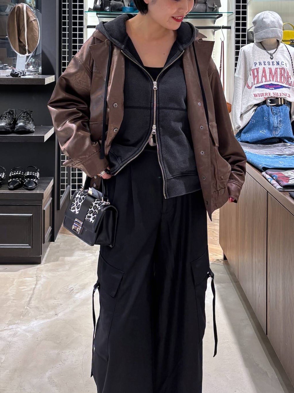 ブラウン系のブルゾン、その他のハンドバッグ、ブラック系のパーカーを着用したレディースの秋コーディネートの2枚目の写真