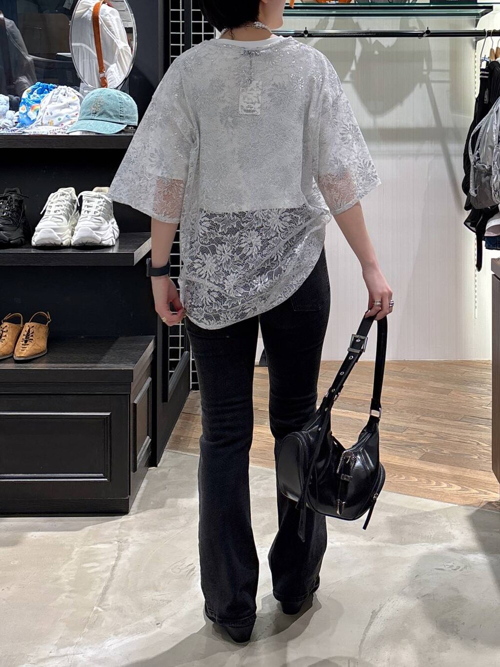 ブラック系のデニムパンツ、ブラック系のパンプス、ブラック系のショルダーバッグを着用したレディースの夏コーディネートの4枚目の写真