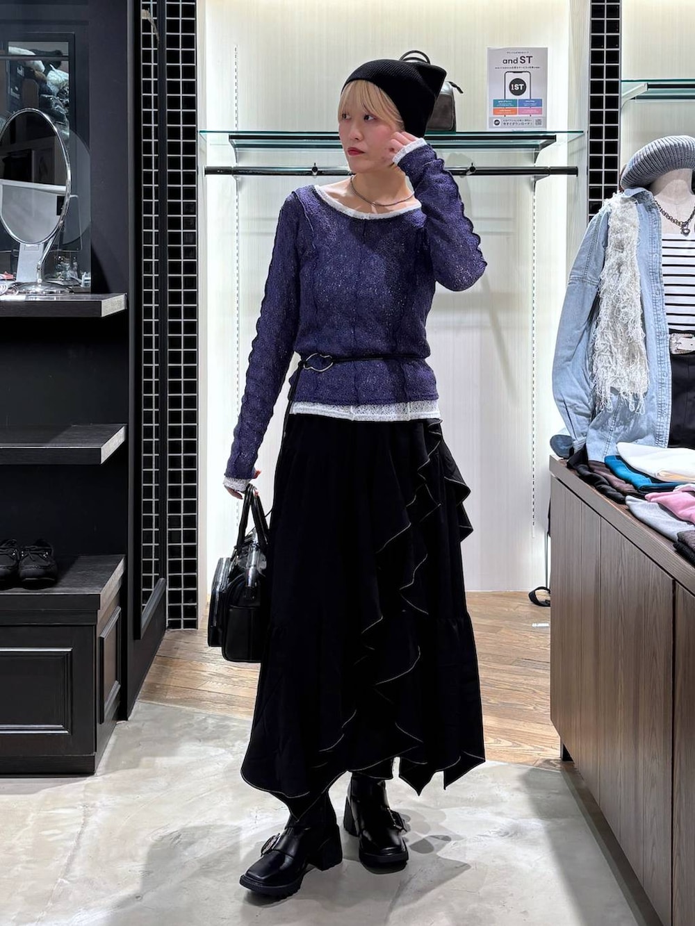 ブラック系のブーツ、ブラック系のスカート、ブラック系のショルダーバッグを着用したレディースの春コーディネートの9枚目の写真