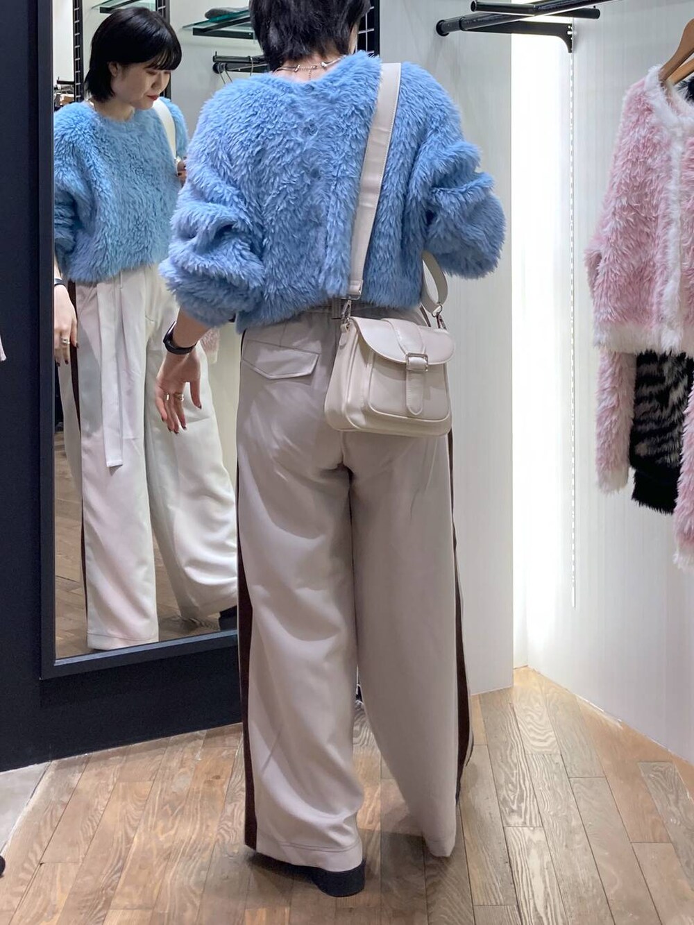 ホワイト系のショルダーバッグ、ベージュ系のその他パンツ、シルバー系のネックレスを着用したレディースの秋コーディネートの2枚目の写真