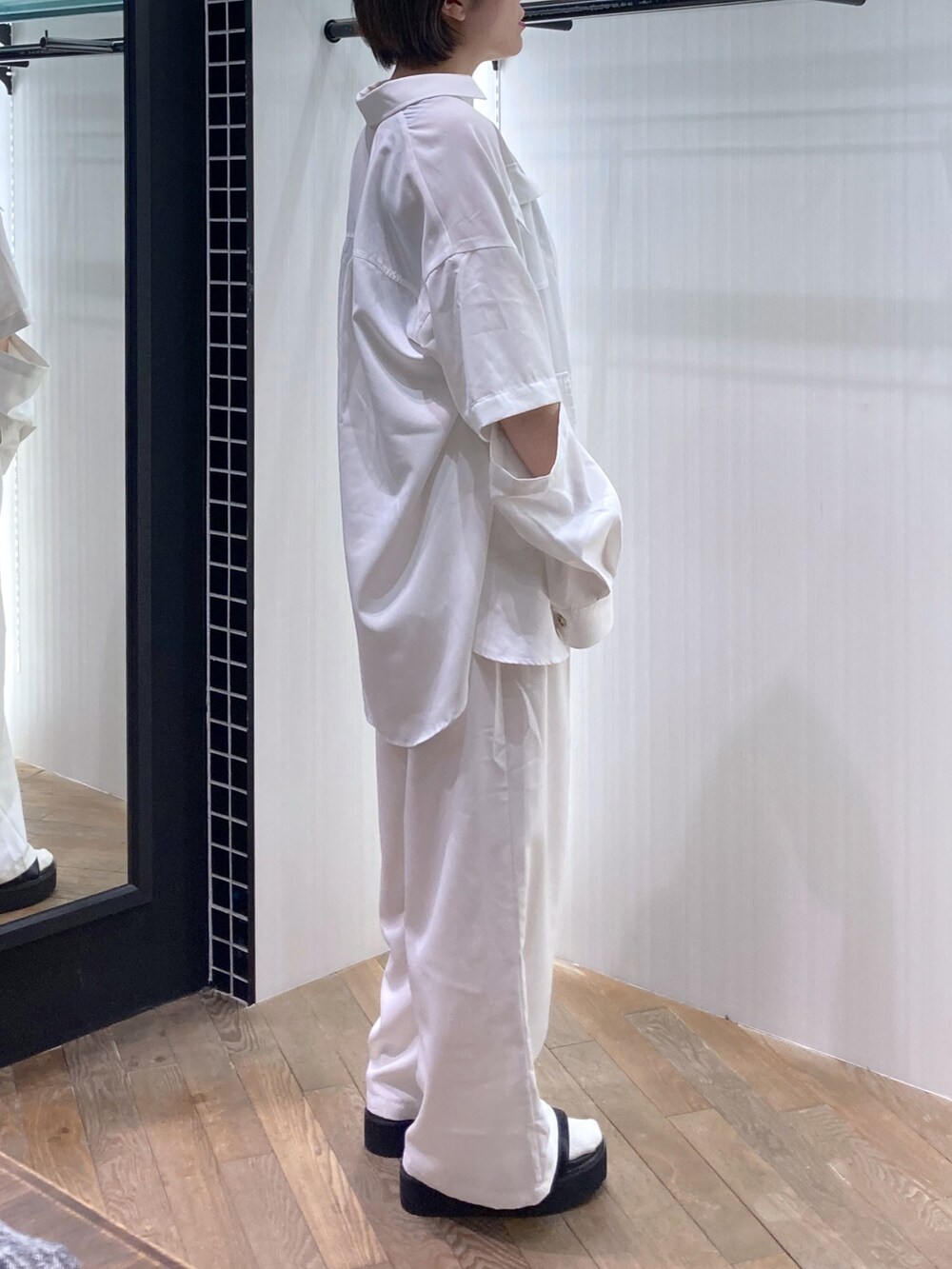 ブラック系のタンクトップ、ホワイト系のシャツ/ブラウス、ホワイト系のパンツを着用したレディースの春コーディネートの3枚目の写真