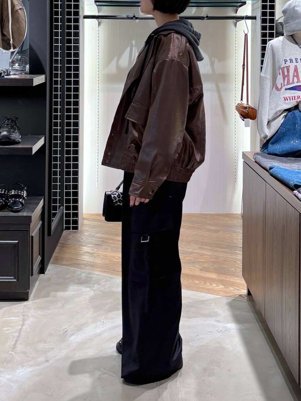 ブラウン系のブルゾン、その他のハンドバッグ、ブラック系のパーカーを着用したレディースの秋コーディネートの5枚目の写真