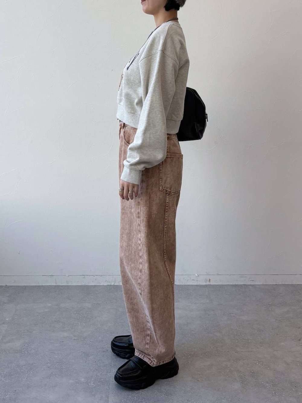 ブラック系のボストンバッグ、ブラック系のローファー、ブラウン系のデニムパンツを着用したレディースの冬コーディネートの3枚目の写真