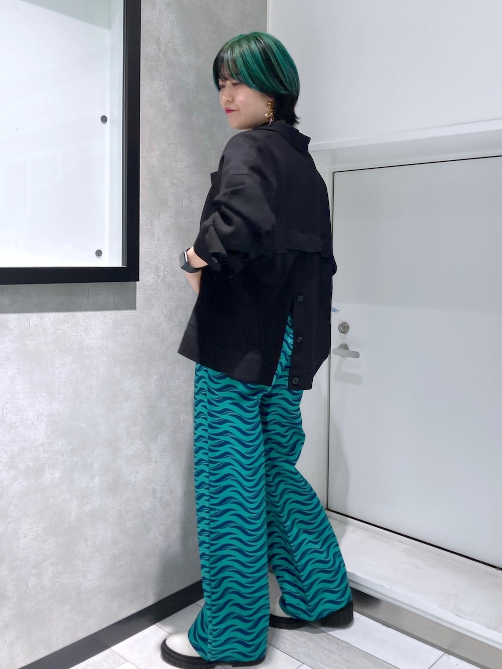 ホワイト系のTシャツ/カットソー、ブラック系のミリタリージャケット、グリーン系のパンツを着用したレディースの春コーディネートの3枚目の写真