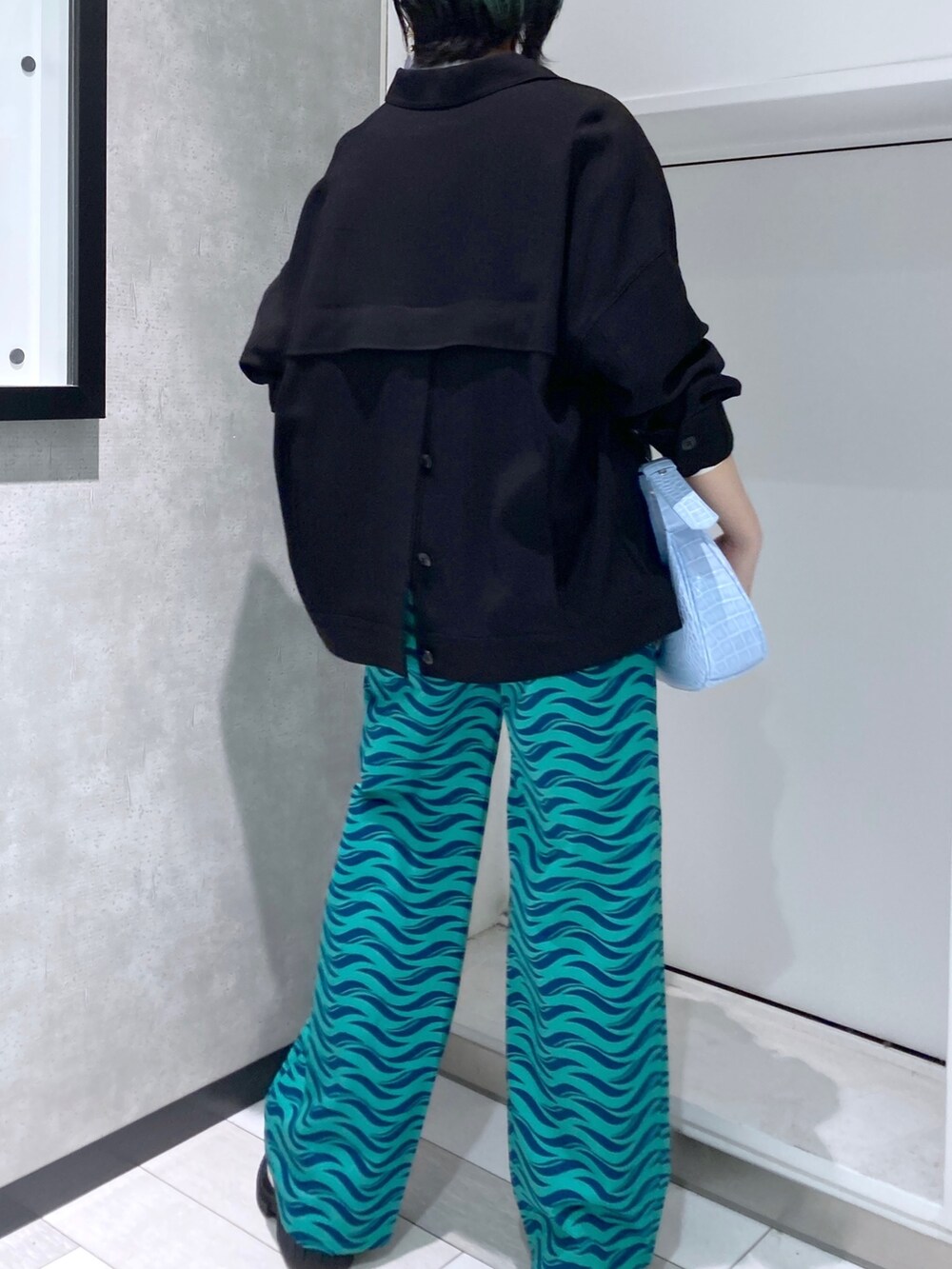 ホワイト系のTシャツ/カットソー、ブラック系のミリタリージャケット、グリーン系のパンツを着用したレディースの春コーディネートの2枚目の写真