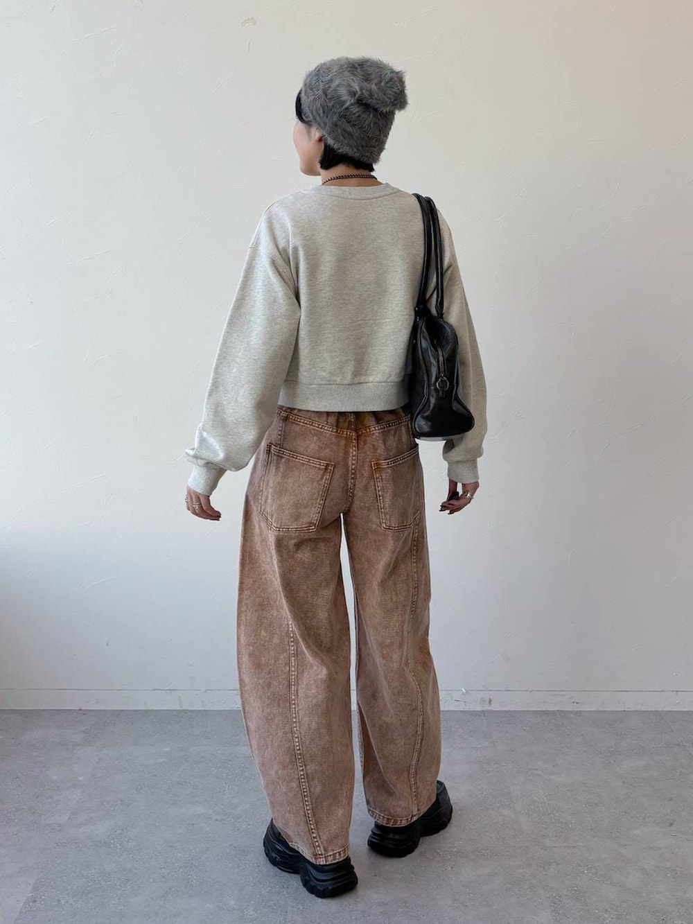 ブラック系のボストンバッグ、ブラック系のローファー、ブラウン系のデニムパンツを着用したレディースの冬コーディネートの6枚目の写真