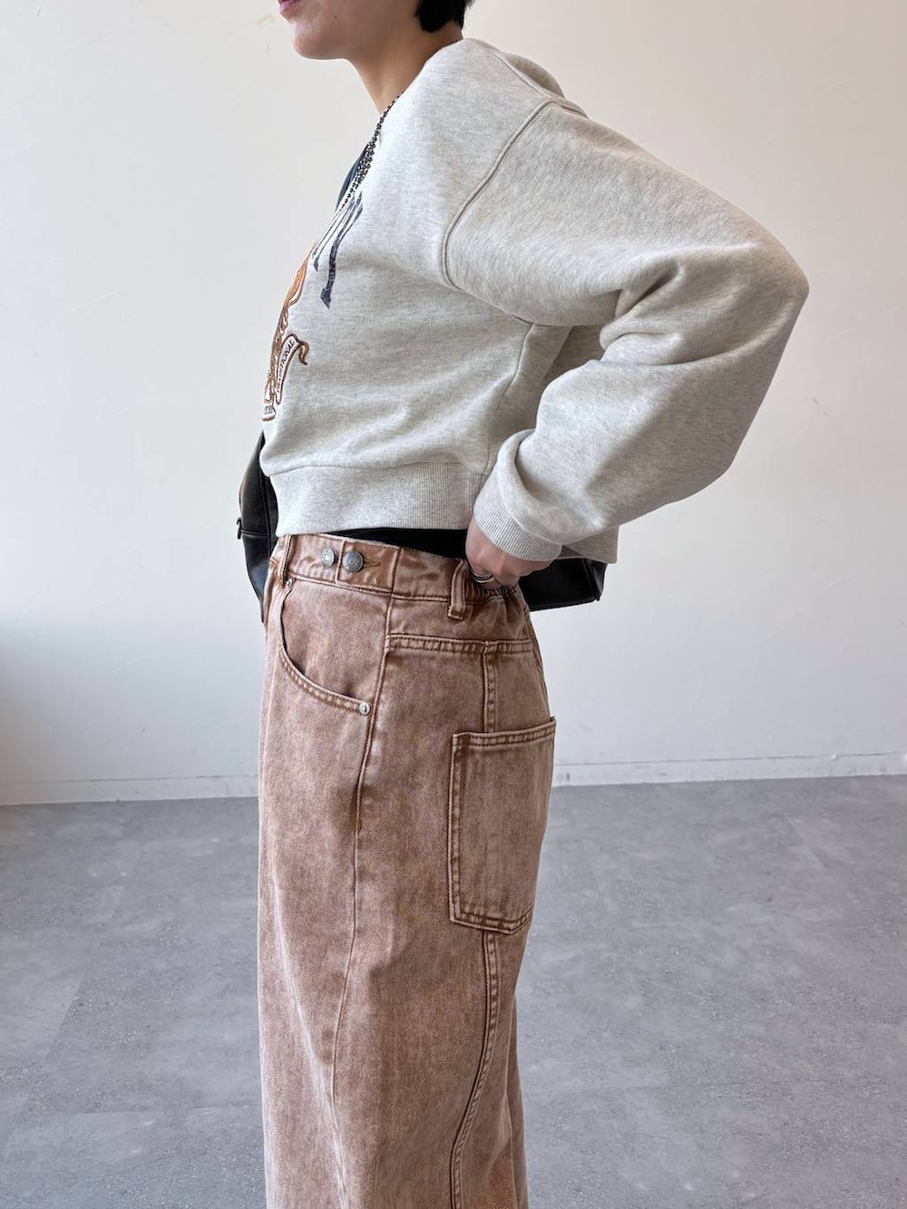 ブラック系のボストンバッグ、ブラック系のローファー、ブラウン系のデニムパンツを着用したレディースの冬コーディネートの5枚目の写真