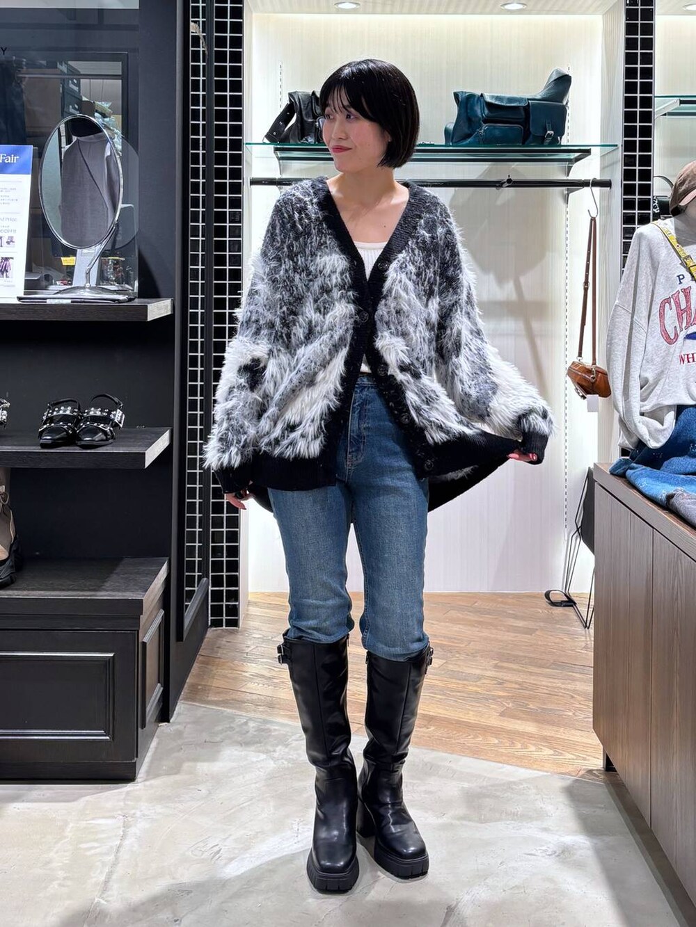 ホワイト系のタンクトップ、ブラック系のカーディガン/ボレロ、ブラック系のブーツを着用したレディースの秋コーディネートの8枚目の写真