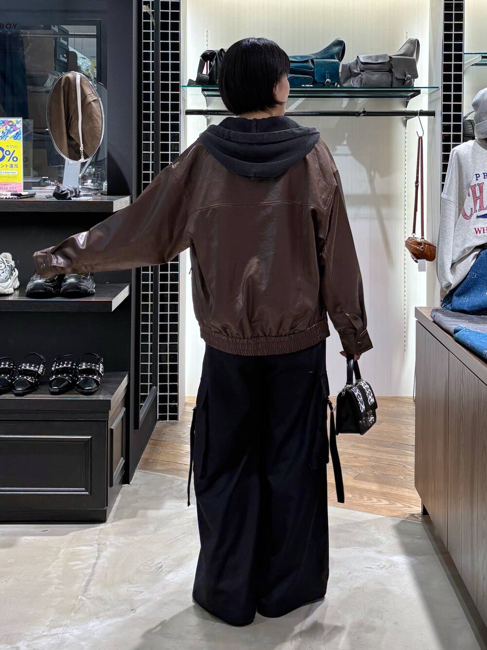 ブラウン系のブルゾン、その他のハンドバッグ、ブラック系のパーカーを着用したレディースの秋コーディネートの4枚目の写真