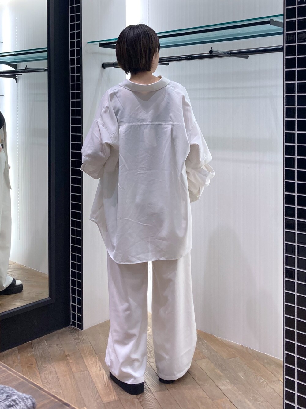 ブラック系のタンクトップ、ホワイト系のシャツ/ブラウス、ホワイト系のパンツを着用したレディースの春コーディネートの2枚目の写真