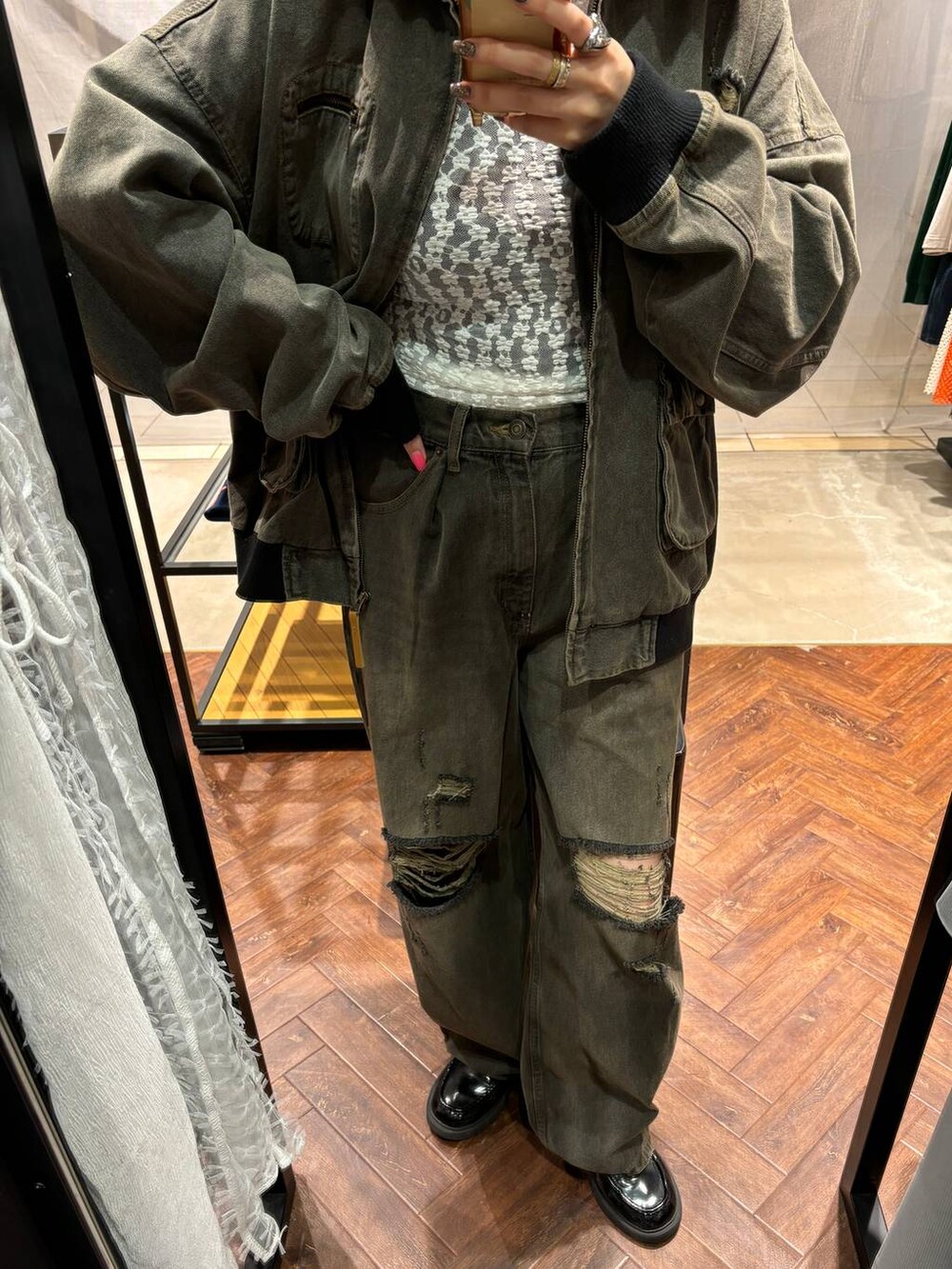 ブラック系のブルゾン、ブラック系のデニムパンツを着用したレディースの冬コーディネートの4枚目の写真