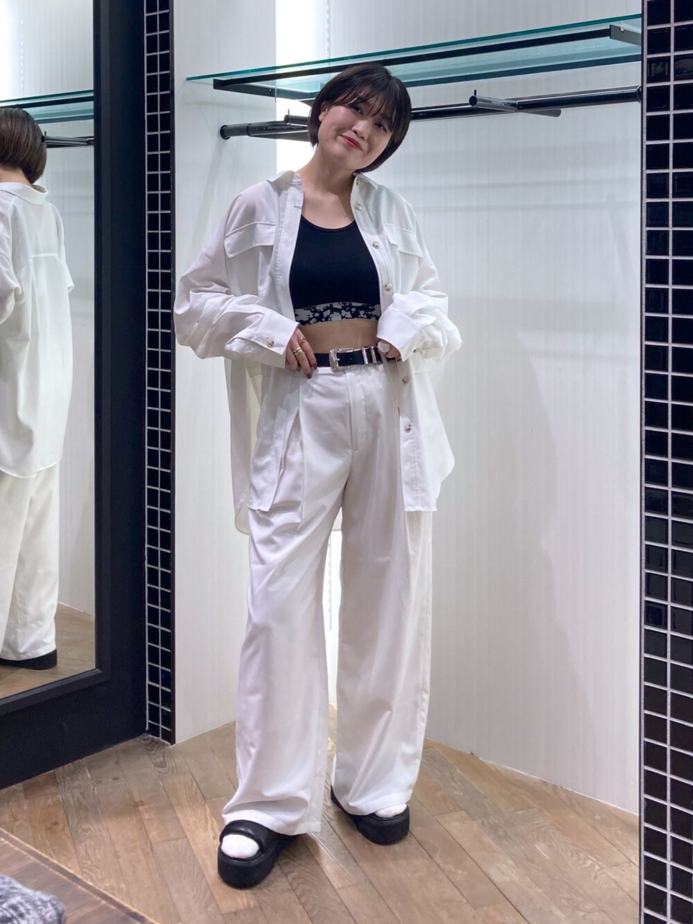 ブラック系のタンクトップ、ホワイト系のシャツ/ブラウス、ホワイト系のパンツを着用したレディースの春コーディネートの5枚目の写真