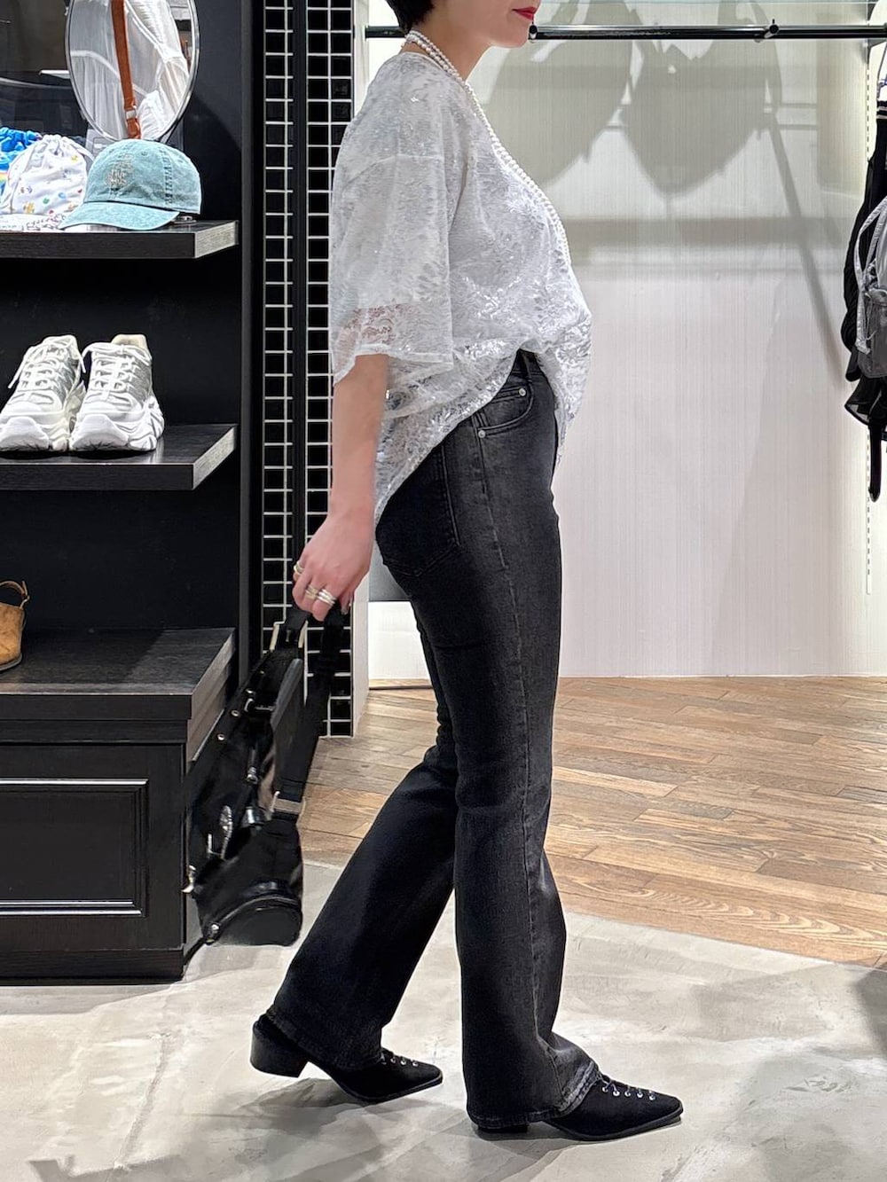 ブラック系のデニムパンツ、ブラック系のパンプス、ブラック系のショルダーバッグを着用したレディースの夏コーディネートの5枚目の写真