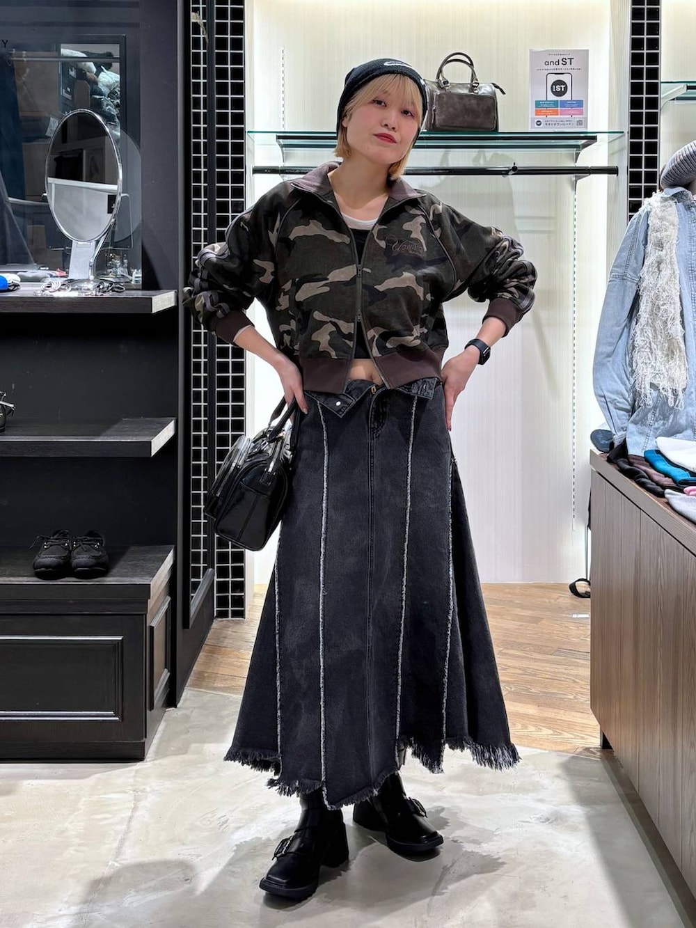 ブラック系のブーツ、ブラック系のショルダーバッグ、ブラック系のデニムスカートを着用したレディースの春コーディネートの7枚目の写真